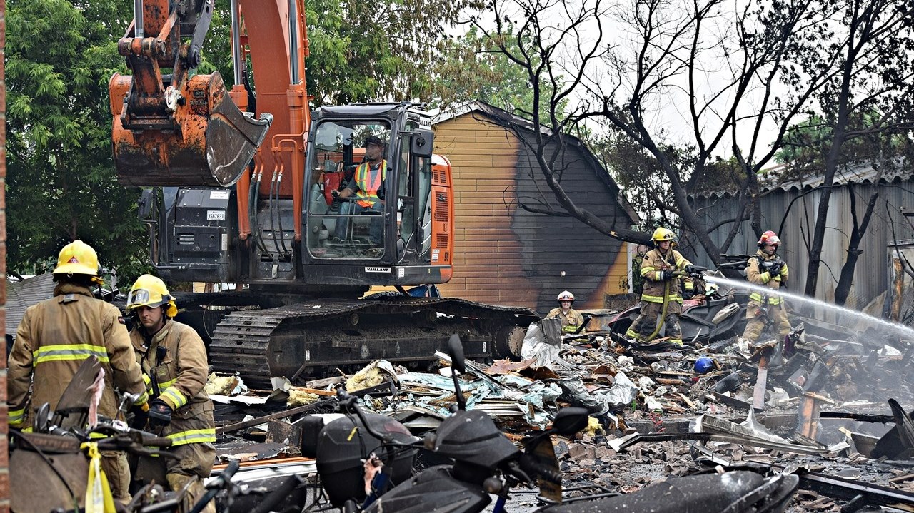 Firefighters clean up after a fire destroyed Séguin Sport in Rigaud this morning.