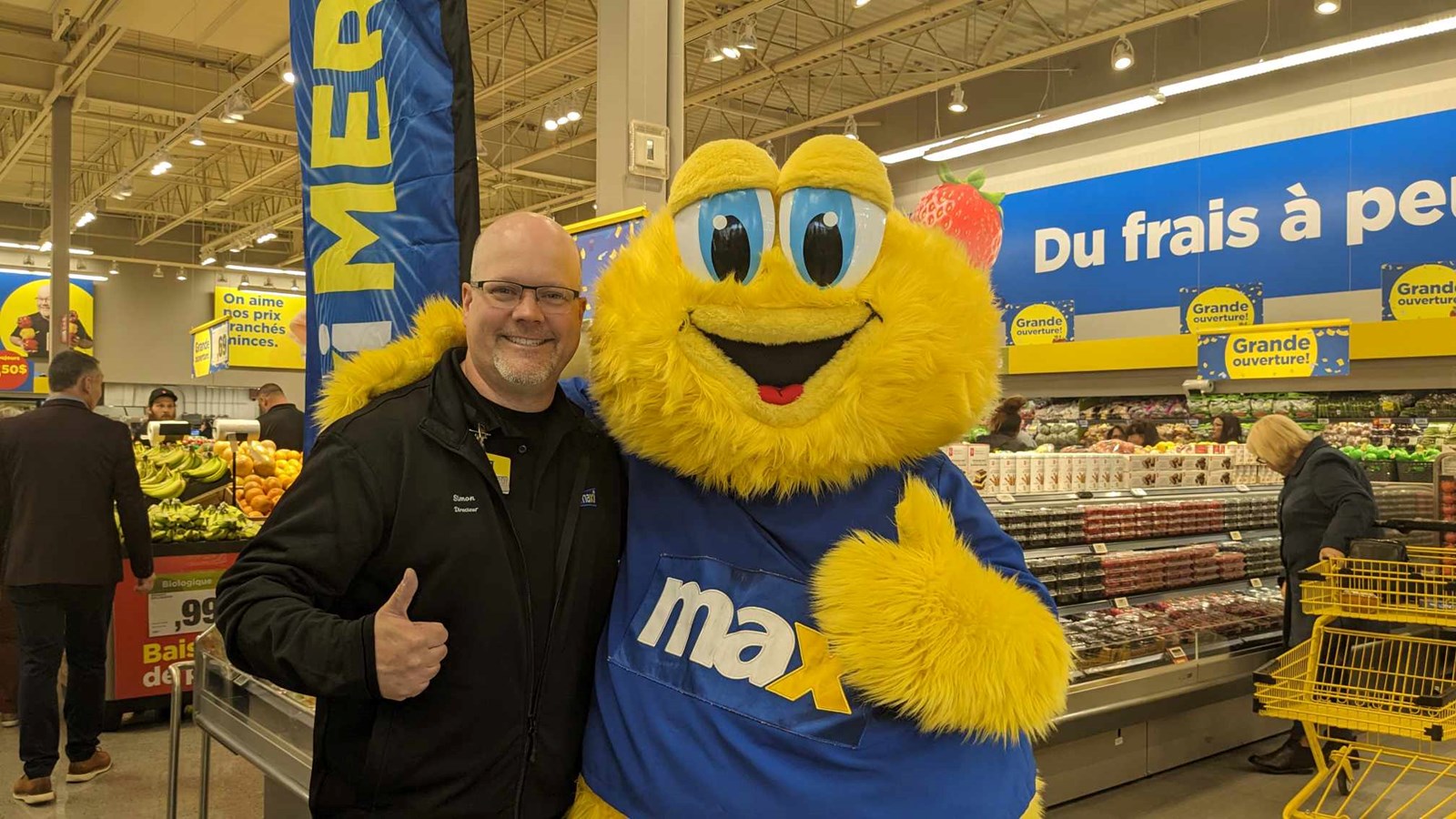 Store manager Simon Legault poses with Max, the grocery chain's official mascot