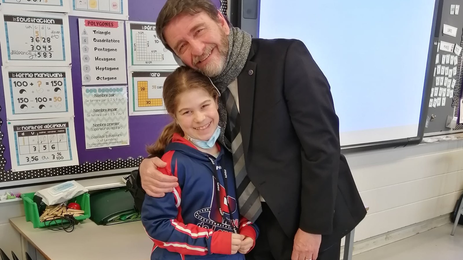Sur celle-ci, il prend la pose avec Florence, sa nièce, dans le cadre d'une visite à son école, une des activités favorites de M. D'Aoust, soit motiver les enfants - en dehors de ses journées sur le terrain