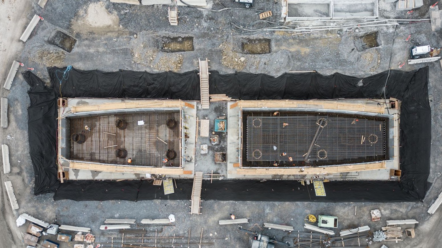 Workers laying steel reinforcement in the footings of a pier, May 2024 