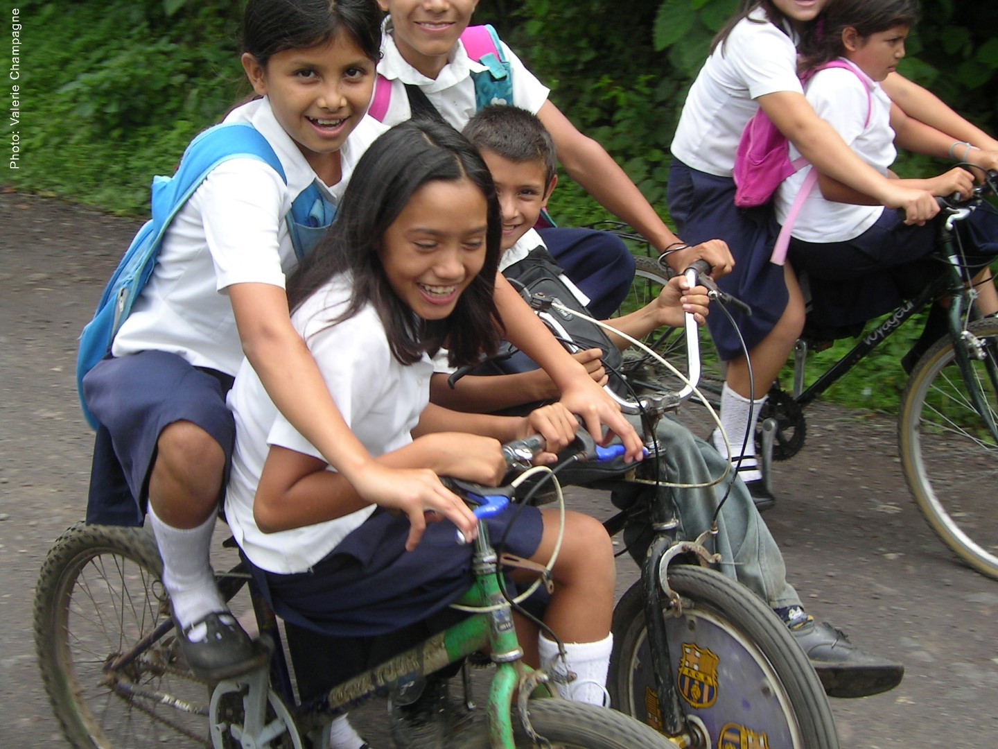 Des écolières du Salvador se partageant une bicyclette obtenue grâce à l’organisme Cyclo Nord-Sud.(Photo : Valérie Champagne)