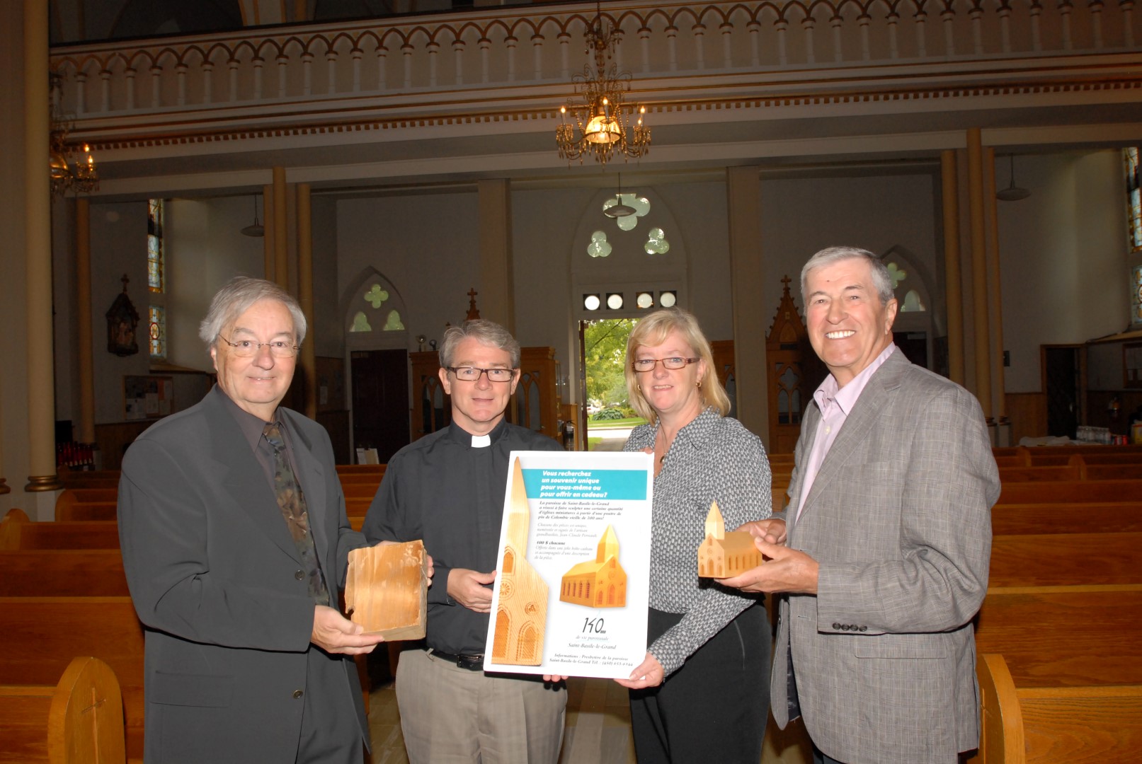 Gilles Monette, marguillier responsable de la campagne de financement 2011, Bruno Godin, curé de la paroisse, Josée La Forêt, présidente de la Fabrique de la paroisse Saint-Basile-le-Grand, et Jean-Claude Perreault, tourneur de bois, ont procédé au dévoilement des petites églises le 14 septembre dernier. (Photo : Luc Girard)