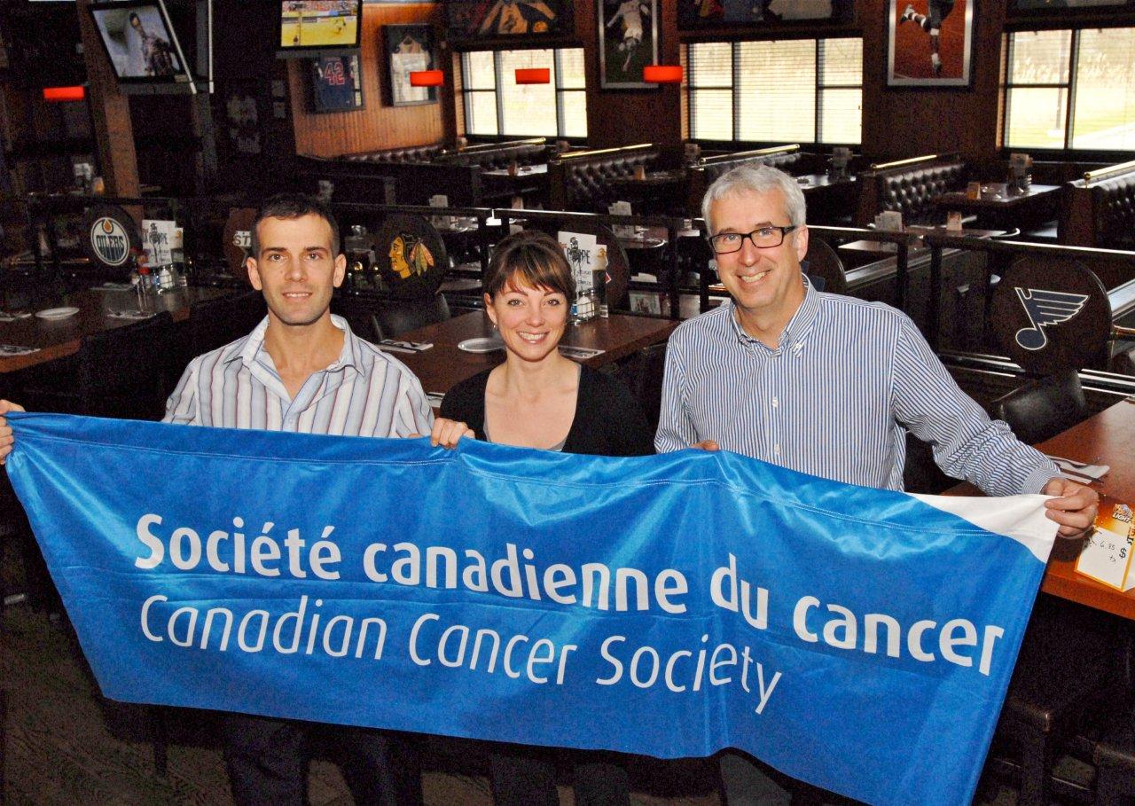 Alexandre Champagne et Véronick Morin, gérants de La Cage aux Sports de Saint-Bruno-de-Montarville, et François St-Pierre, de la succursale de Mont-Saint-Hilaire, organise une soirée Interboxe au profit de la Société canadienne du cancer.