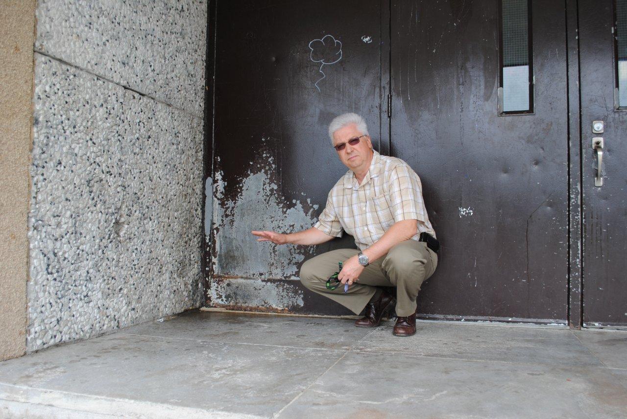 Claude Lapointe, directeur de l’école Jacques-Rocheleau, est fatigué que des jeunes vandalisent jour après jour son établissement. Sur la photo, il montre un endroit précis où des bouteilles de bière fracassées ont été retrouvées, ainsi que de l’urine.