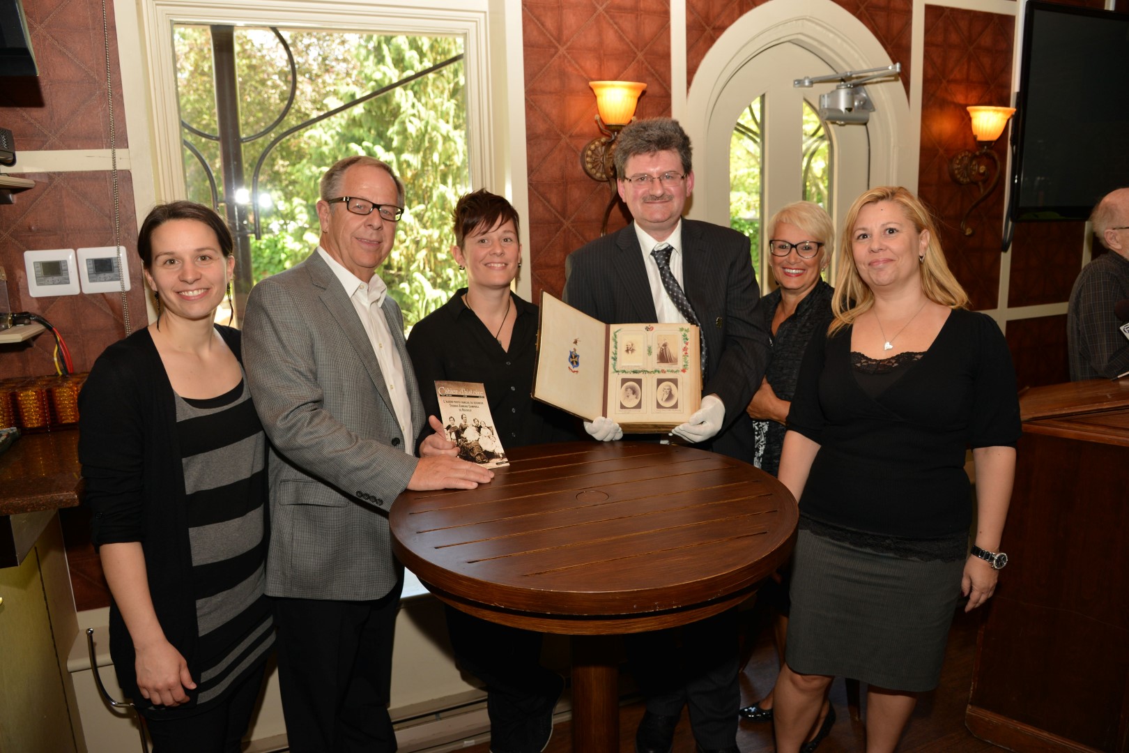 La famille Imbeau, soit Marie-Claude, André, Christine, Noëlla et Caroline, entoure Alain Côté, président de la Société d'histoire de Belœil–Mont-Saint-Hilaire.
