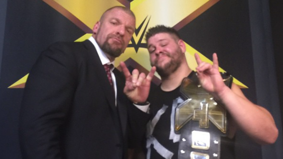 Triple H félicite Kevin Owens pour son championnat.