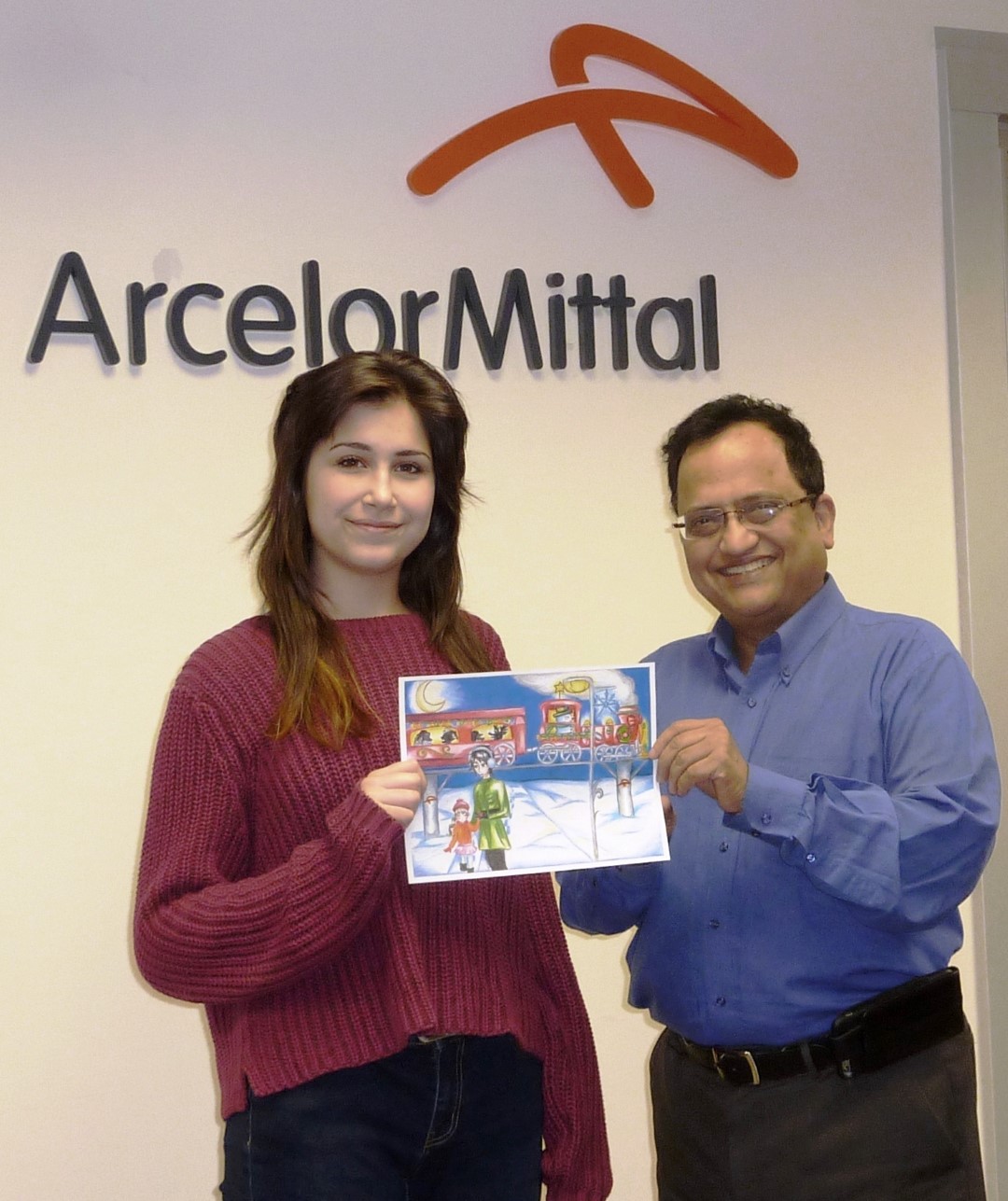 Sujit Sanyal, vice-président, Opérations d’ArcelorMittal Montréal et Myriam Charland posent avec le dessin de Myriam