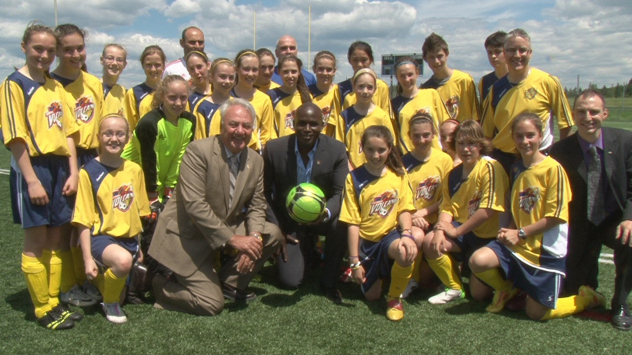 Ali Gerba, en compagnie du maire François Fecteau (gauche), de Marco Gagné du Cégep Beauce-Appalaches (droite), ainsi que de l'équipe de soccer Volcano U13.