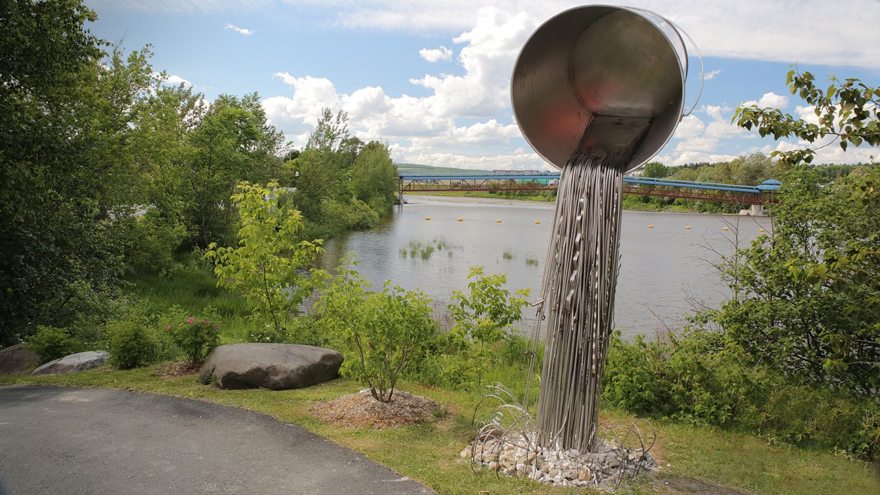 L'oeuvre de Don Darby donne l’illusion d’un seau suspendu dans le vide qui déverse son contenu aux abords de la rivière Chaudière.