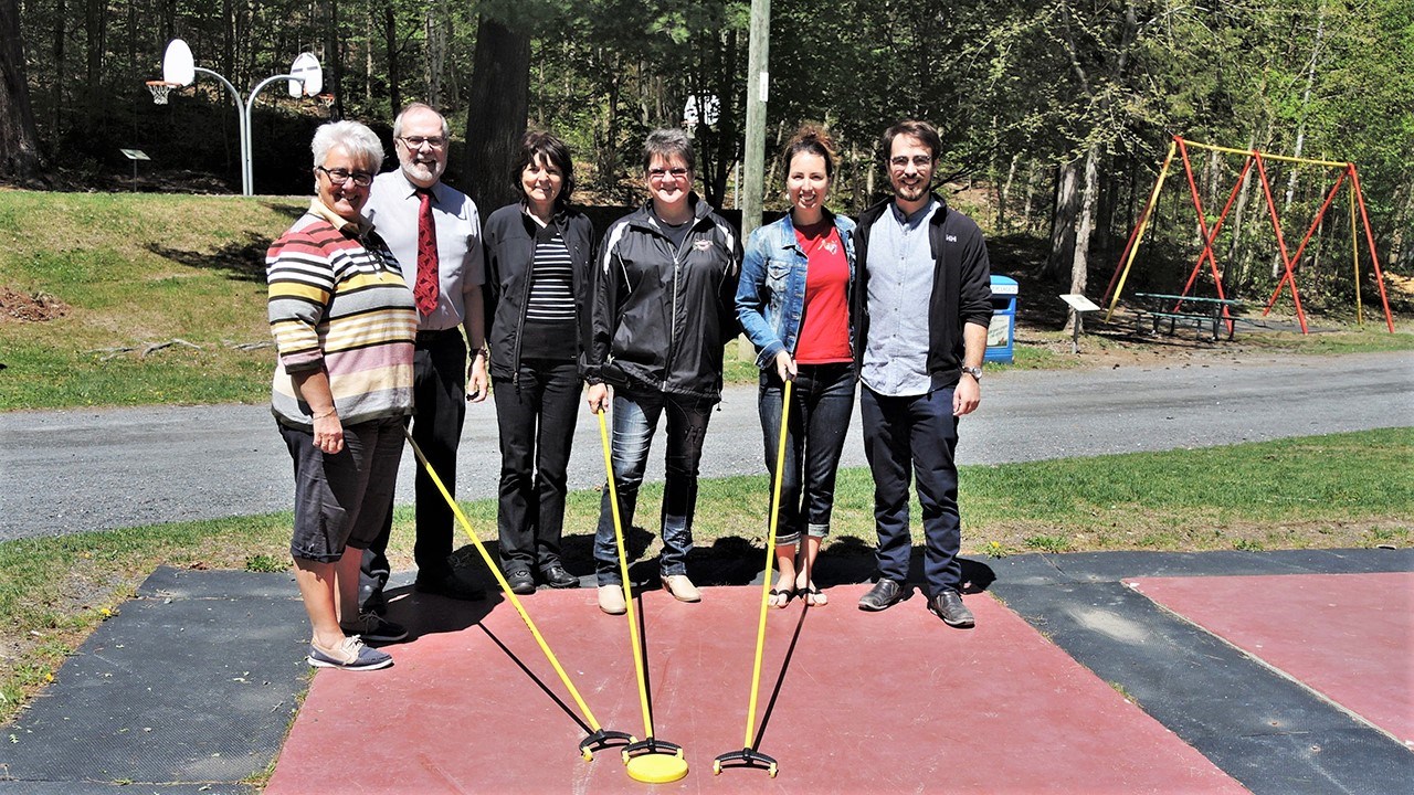De gauche à droite : Sur les terrains de shuffleboard, Carole Paquet, directrice du Service des loisirs de la Ville de Saint-Georges, Claude Morin, maire de la Ville de Saint-Georges, Johanne Veilleux, du Groupe des ornithologues de la Beauce-Etchemin, Sylvie Roy, de Country Dance S.R., Virginy, de la Cabane à Swing, et Samuel Duval, stagiaire au Service des loisirs et de la culture de la Ville de Saint-Georges, lors de la conférence de presse annonçant la programmation estivale 2018 au parc des Sept-Chutes de Saint-Georges, jeudi le 24 mai 2018.