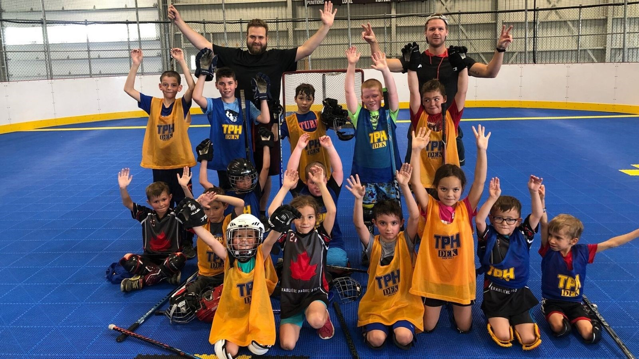 Philippe Garnier et Christopher Rodrigue de Dek Hockey TPH, avec un groupe de jeunes joueurs de dek.