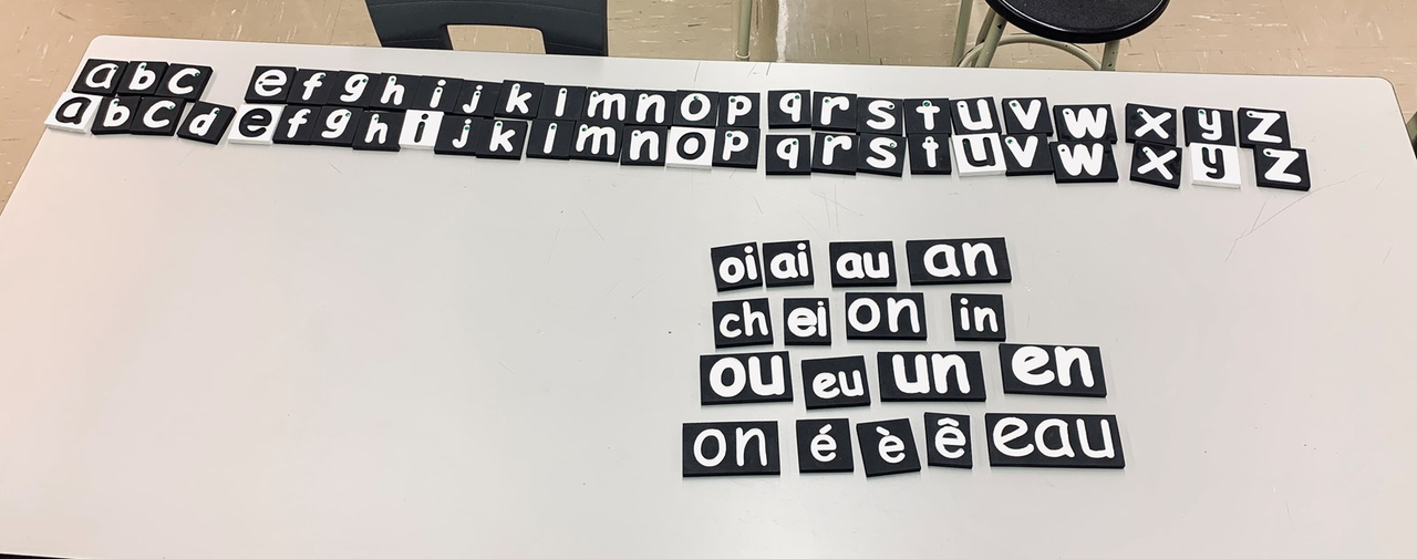 Des lettres et des sons gravés et peinturés permettant aux élèves de la classe COM de manipuler et de toucher la lettre en passant le doigt dans la gravure.