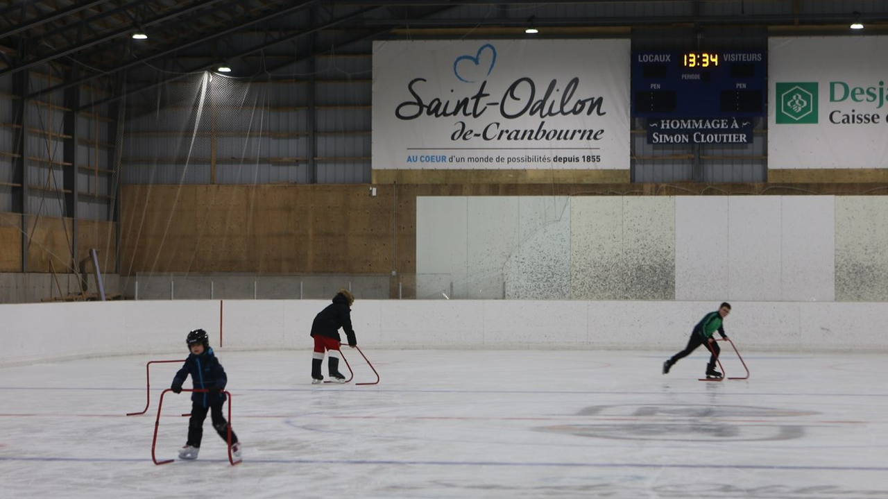 Trois jeunes qui patinent lors du marché de Noël de Saint-Odilon.