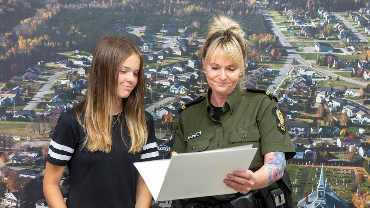 L'agente Marie-Joëlle Girard, coordonnatrice en police communautaire au poste de la MRC Nouvelle-Beauce, remet un certificat de collaboration au nom de la Sûreté du Québec