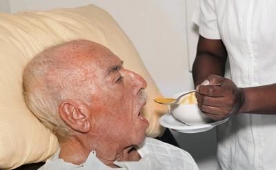 personnes ageessenior male 92 years old being fed by a nurse