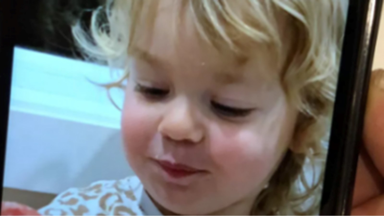 , Liana, mesure 76 centimètres, a les cheveux blonds, les yeux bruns verts et portait un manteau et un legging rouge et blanc