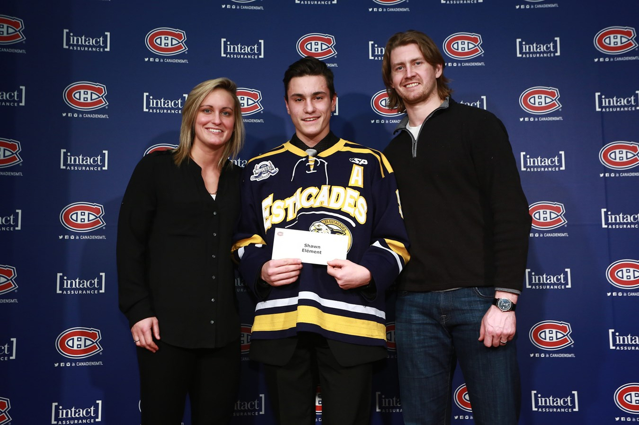 Shawn Élément, au centre, reçoit sa bourse des mains de Marie-Philip Poulin, ancienne boursière et joueuse des Canadiennes de Montréal ainsi que Jeff Petry, défenseur du Canadien de Montréal.