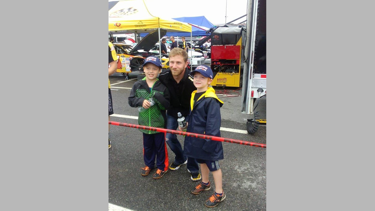 Deux enfants du Centre Arc-en-Ciel en compagnie du pilote Jeffrey Earnhardt.
