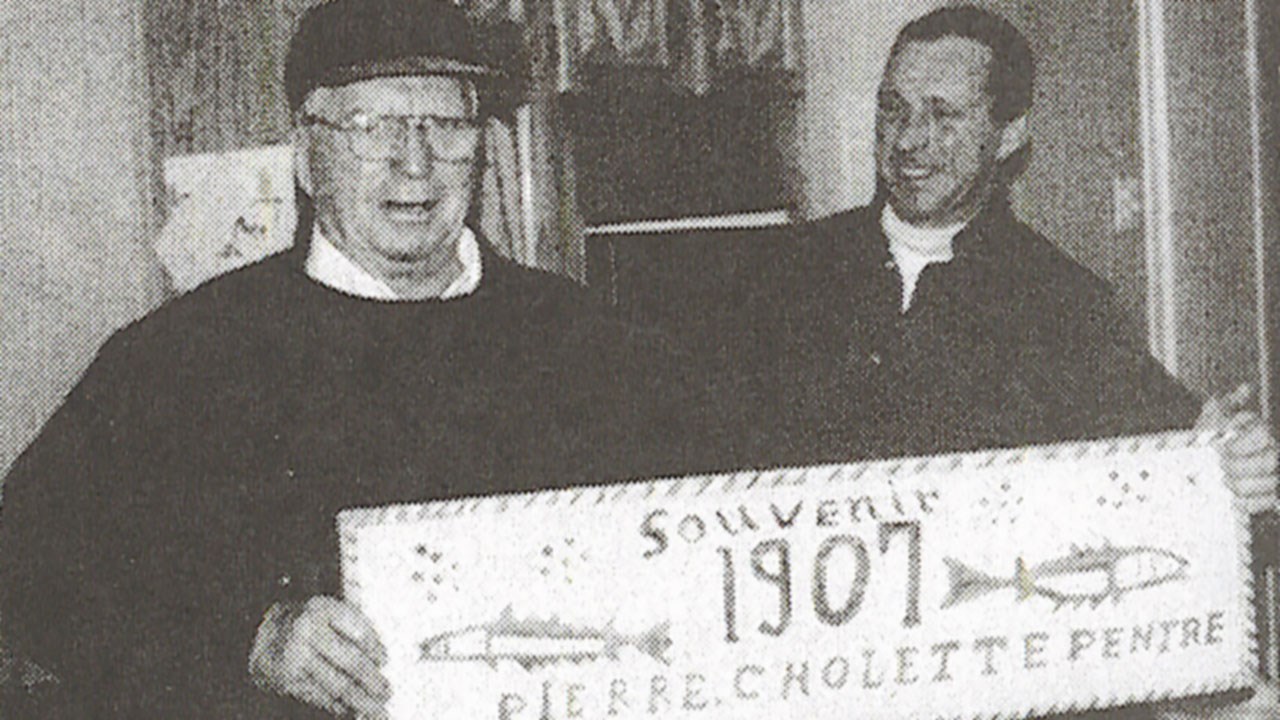 Marcel & son fils Pierre Cholette, tenant l’enseigne de L’Enfant perdu et retrouvé, enlevée du pignon de l'école que Pierre Cholette a peint vers 1907.