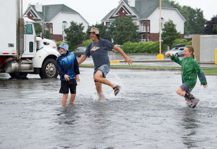 Les membres de la famille Morin s'amusent à courir dans l'eau qui s'est accumulée à Sainte-Thérèse en raison des fortes pluies qui se sont abattues, le samedi 11 août 2012.
MARTIN ALARIE/AGENCE QMI