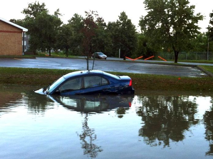 Une voiture se trouvant dans le stationnement d'une épicerie IGA se retrouve fortement inondée, en raison des fortes pluies qui sont survenues dans le secteur, le samedi 11 août 2012.
MARTIN ALARIE/AGENCE QMI