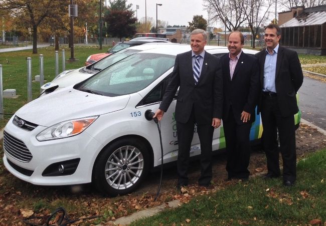 Le maire de Blainville, François Cantin, Michel Larue, directeur du Service de l’urbanisme et de l’aménagement durable du territoire, et Sylvain Langis d’Hydro-Québec rechargent une voiture électrique grâce à une nouvelle borne. 