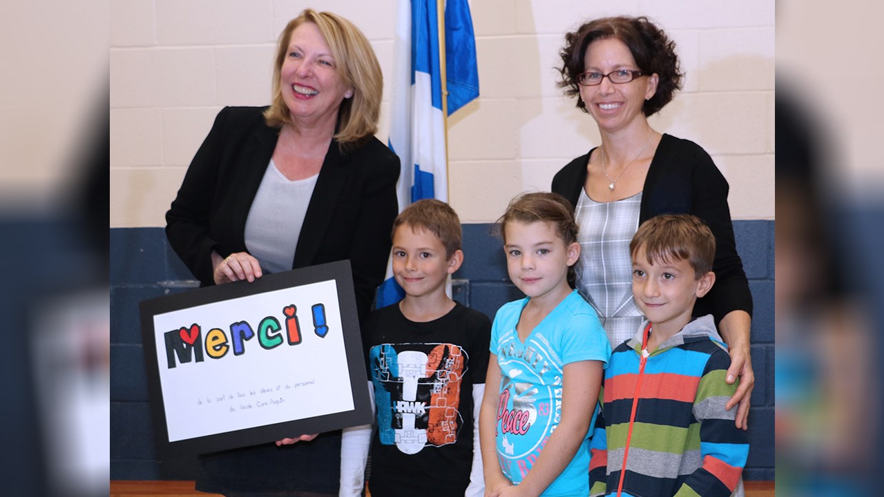 La ministre, Christine St-Pierre a reçu un cadeau de la part des élèves de l’école Curé-Paquin. Elle pose fièrement ici avec Charly, Kellyane,  Samuel et leur enseignante, Isabelle Langlois.