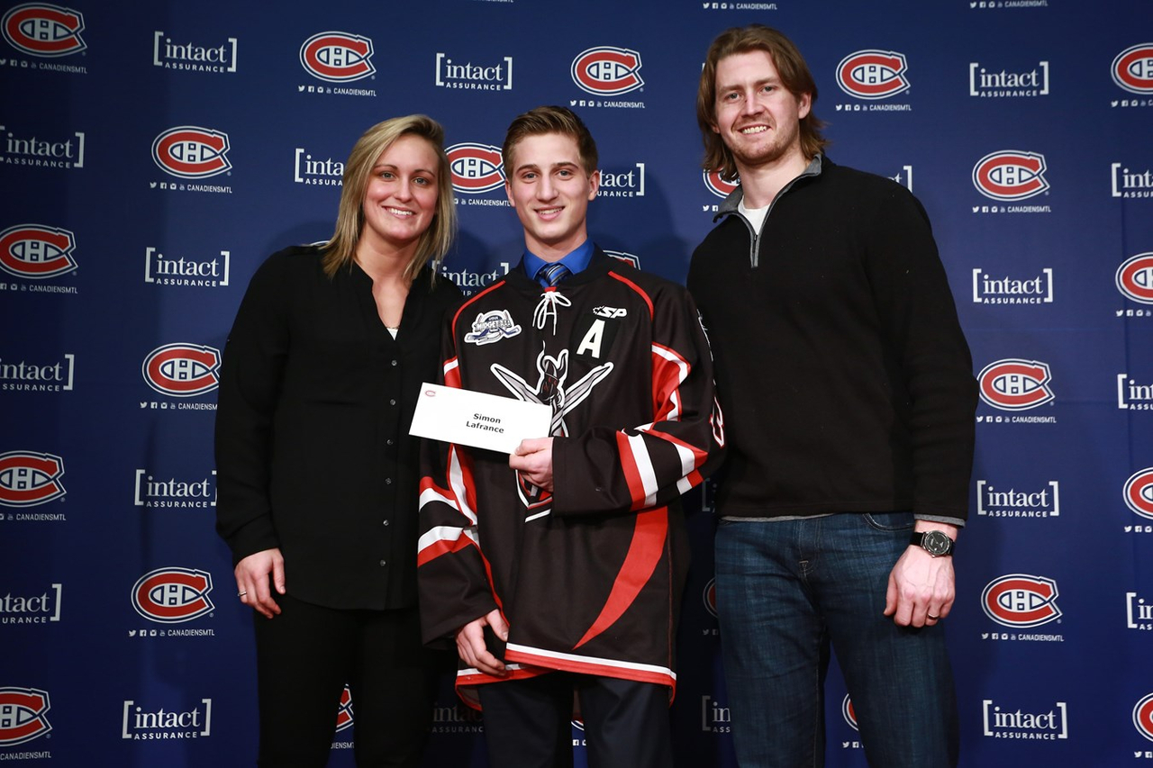 Simon Lafrance, au centre, reçoit sa bourse des mains de Marie-Philip Poulin, ancienne boursière et joueuse des Canadiennes de Montréal ainsi que Jeff Petry, défenseur du Canadien de Montréal.