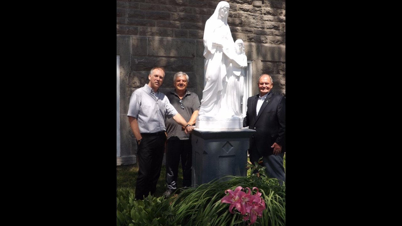 Alain Cassista, directeur général de la ville, Yvon Charbonneau, président de la Société Héritage Anneplainois et Guy Charbonneau, maire encadrent la statue restaurée.