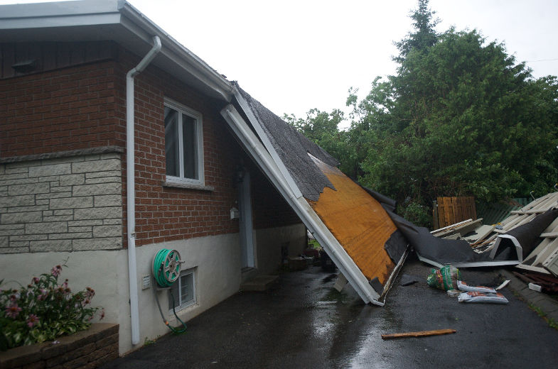 Le mauvais temps et des orages violents ont frappé plusieurs régions du Québec. Dans la province, près de 487 000 abonnés étaient privés d’électricité vers 16 h, le vendredi 19 juillet 2013, selon Hydro-Québec. Sur la photo, un toit arraché sur la rue Neuville, dans le quartier Vimont, à Laval.
JACQUES PHARAND/L'ÉCHO DE LAVAL/AGENCE QMI