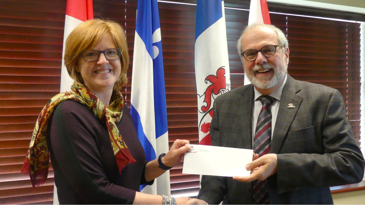 Le maire, Claude Morin, en train de féliciter Louise Champagne.