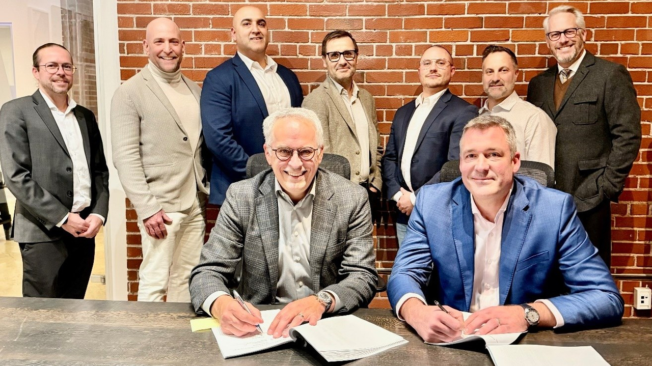 Martin Jacques, chef des opérations chez Pomerleau, et Eric Desaulniers, président et chef de la direction de NMG, officialisent un nouveau chapitre dans leur collaboration en présence des membres clés de l’équipe
