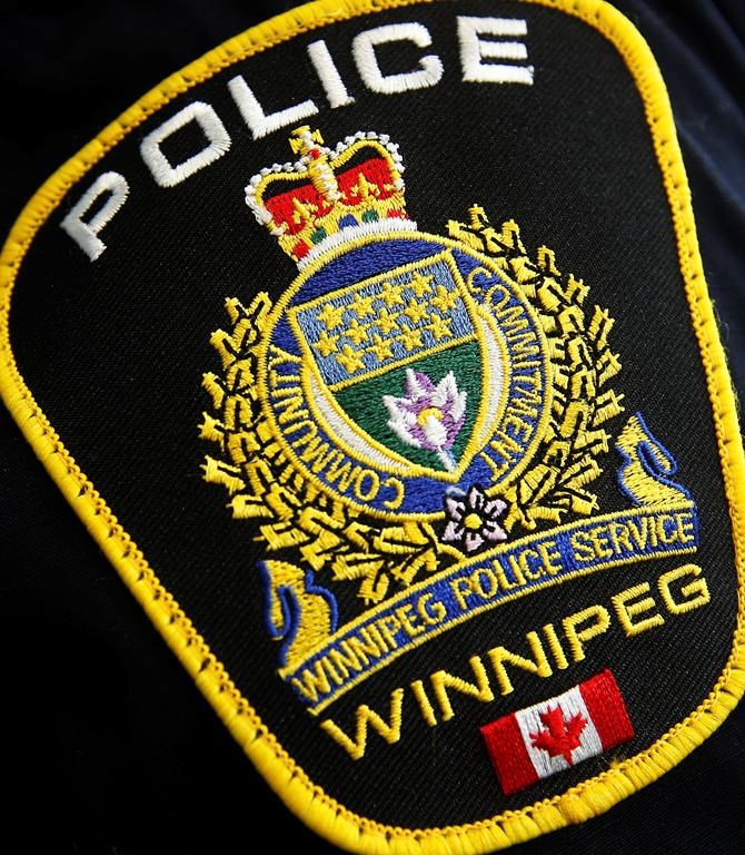 Des manifestants collent des affiches aux fenêtres d'un poste de police de Winnipeg