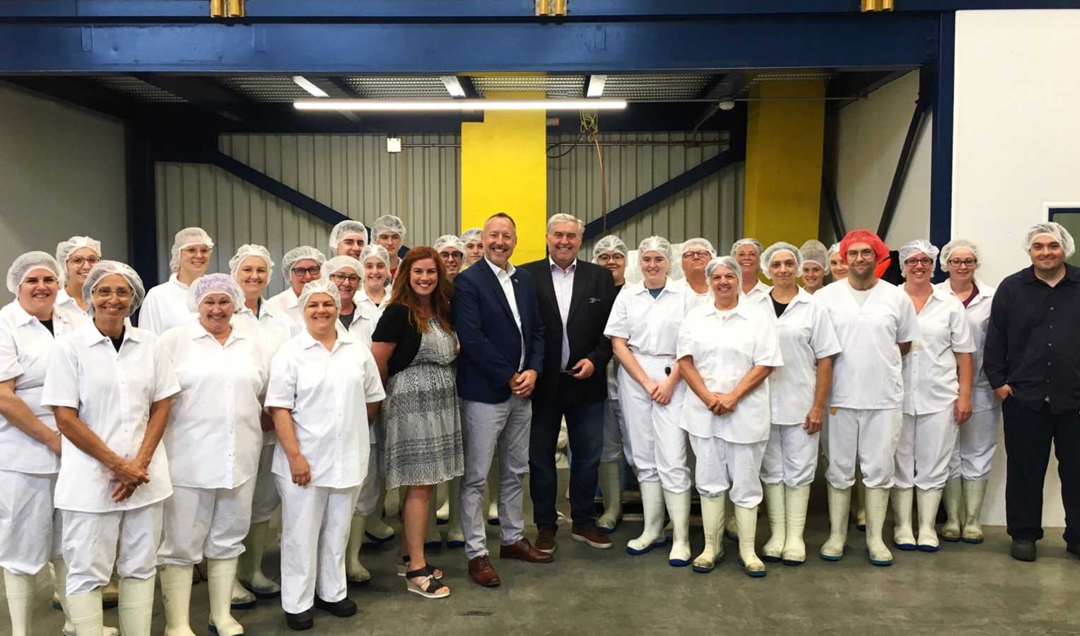 e député de Richelieu, M. Jean-Bernard Émond et le président de la Fromagerie Polyethnique Le Bédouin, M. Jean-Pierre Salvas, entourés des employés de l’entreprise.
