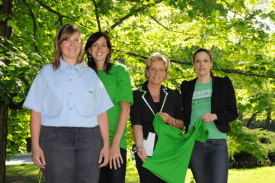 Deux employés de la Ville de Rosemère portent les nouveaux vêtements, alors que la mairesse, Hélène Daneault, et la designer, Sophie Veilleux, tiennent fièrement l un des chandails pour les jeunes inscrits au camp de jour. Crédit: Josiane Yelle