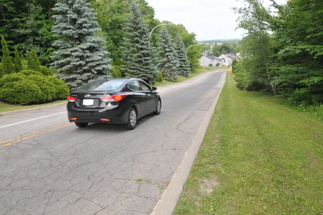 Les automobiles passent vite sur la côte de la rue de Joutel entre les quartiers résidentiels du haut et du bas de la rue.