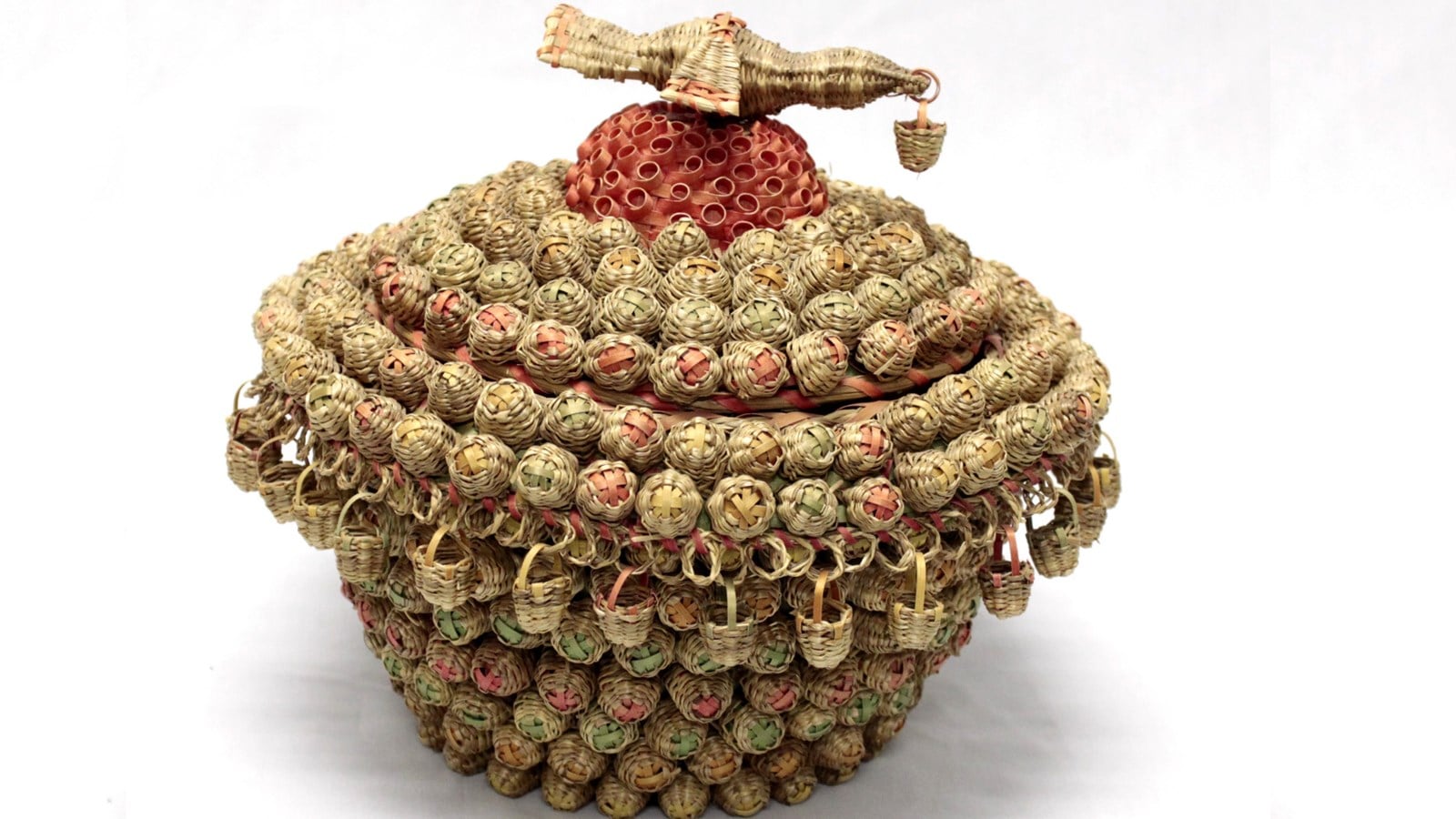 Panier de mariage fait par Émilia M’Sadoques vers 1987. Il est entièrement recouvert de 412 paniers miniatures. Un oiseau en foin d’odeur orne le centre du couvercle.